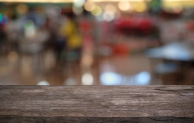 Restoranın soyut bulanık arka planının önündeki boş, siyah ahşap masa. Ürünlerinizi görüntülemek ya da montajlamak için kullanılabilir.
