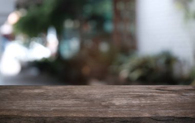 Restoranın soyut bulanık arka planının önündeki boş, siyah ahşap masa. Ürünlerinizi görüntülemek ya da montajlamak için kullanılabilir.