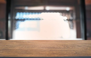 Restoranın soyut bulanık arka planının önündeki boş, siyah ahşap masa. Ürünlerinizi görüntülemek ya da montajlamak için kullanılabilir. 
