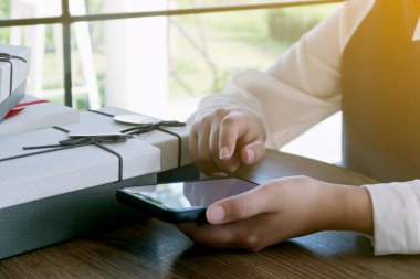 Asyalı kızlar ellerinde akıllı telefon alışverişi hediyeleri tutuyorlar. Alışveriş merkezinde tüketim yaşam tarzı kavramı 