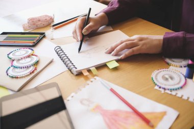 Moda tasarımcısı atölyedeki yeni koleksiyonun taslağı olarak çalışıyor. Yaratıcı Tasarım Konsepti.