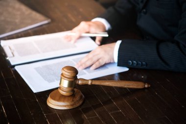 Hukuk danışmanı müvekkiline tokmak ve hukuk hukuku ile imzalanmış bir sözleşme sunar. Adalet ve avukat kavramı