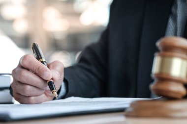 Hukuk danışmanı müvekkiline tokmak ve hukuk hukuku ile imzalanmış bir sözleşme sunar. Adalet ve avukat kavramı