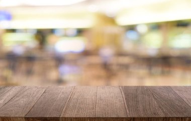 Restoranın soyut bulanık arka planının önündeki boş, siyah ahşap masa. Ürünlerinizi görüntülemek ya da montajlamak için kullanılabilir.