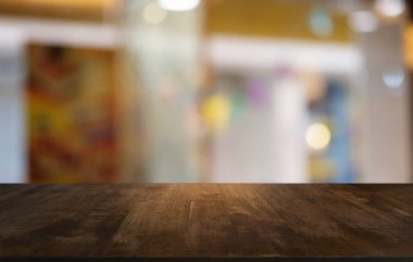 Restoranın soyut bulanık arka planının önündeki boş, siyah ahşap masa. Ürünlerinizi görüntülemek ya da montajlamak için kullanılabilir. 