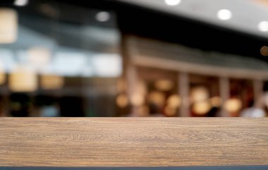 Restoranın soyut bulanık arka planının önündeki boş, siyah ahşap masa. Ürünlerinizi görüntülemek ya da montajlamak için kullanılabilir.
