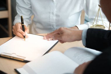Hukuk danışmanı müvekkiline tokmak ve hukuk hukuku ile imzalanmış bir sözleşme sunar. Adalet ve avukat kavramı
