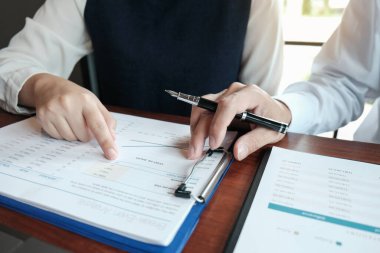 Yatırım çizelgelerini analiz eden ve belgelerin üzerindeki hesap makinesi tuşlarına basan bir işadamı. Muhasebe Kavramı