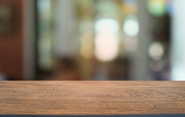 Restoranın soyut bulanık arka planının önündeki boş, siyah ahşap masa. Ürünlerinizi görüntülemek ya da montajlamak için kullanılabilir. 