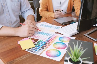 Grafik tasarımcısı dijital tablet üzerinde çalışıyor. Grafik tablet ve renk örneklerine resim çizen sanatçı