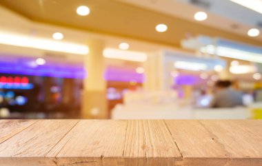 Restoranın soyut bulanık arka planının önündeki boş, siyah ahşap masa. Ürünlerinizi görüntülemek ya da montajlamak için kullanılabilir.