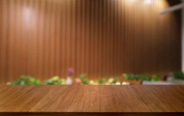 Restoranın soyut bulanık arka planının önündeki boş, siyah ahşap masa. Ürünlerinizi görüntülemek ya da montajlamak için kullanılabilir. 