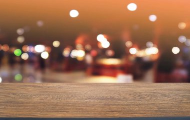 Restoranın soyut bulanık arka planının önündeki boş, siyah ahşap masa. Ürünlerinizi görüntülemek ya da montajlamak için kullanılabilir. 