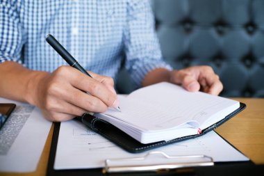 Erkek öğrenci, üniversite kampüsündeki derslere hazırlanırken taşınabilir tabletten bilgi yazar