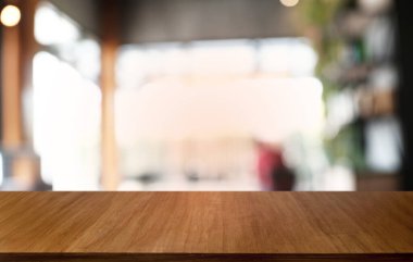 Restoranın soyut bulanık arka planının önündeki boş, siyah ahşap masa. Ürünlerinizi görüntülemek ya da montajlamak için kullanılabilir. 