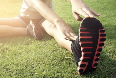 Çekici kadınlar egzersiz yapmadan önce bacaklarını esneterek ısınırlar.