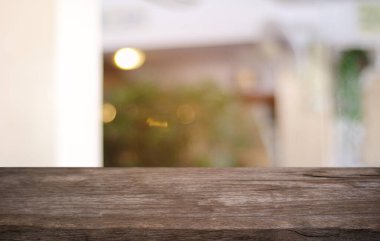Restoranın soyut bulanık arka planının önündeki boş, siyah ahşap masa. Ürünlerinizi görüntülemek ya da montajlamak için kullanılabilir. 
