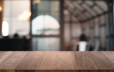Restoranın soyut bulanık arka planının önündeki boş, siyah ahşap masa. Ürünlerinizi görüntülemek ya da montajlamak için kullanılabilir. 