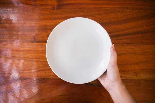 Θηλυκό Γυναίκα Χέρια Κρατήστε Υποστήριξη Ένα Λευκό Πιάτο Πιάτο Ξύλινο — Φωτογραφία Αρχείου