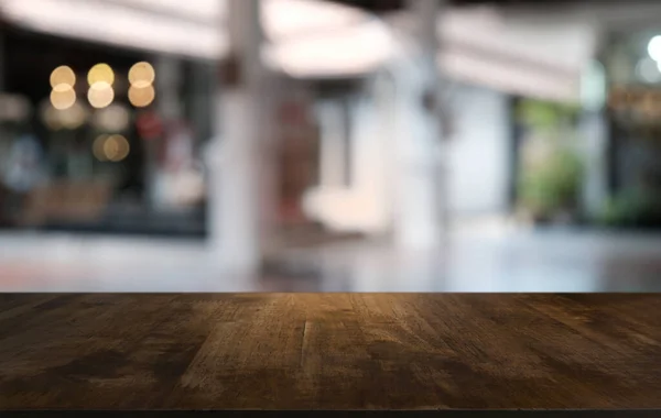 Restoranın soyut bulanık arka planının önündeki boş, siyah ahşap masa. Ürünlerinizi görüntülemek ya da montajlamak için kullanılabilir.
