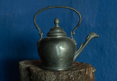 Eski bakır çaydanlık mavi arka planda tahta bir tahtada.