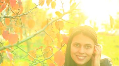 sonbahar günü sıcak bir Park City'de bir elma ağacı yanında güzel bir kadın gülümsüyor