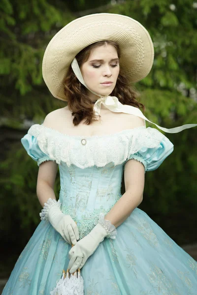 beautiful girl in a hat, historical dress, gloves, with a umbrella in her hands