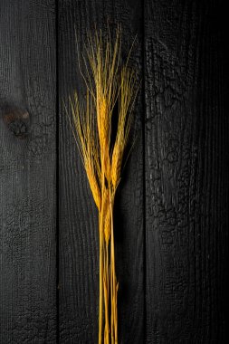 dikey bileşim, buğday kulaklarıyla siyah yanmış tahtalar üzerinde yaşam devam ediyor.