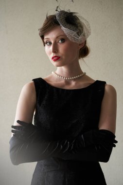 Siyah şapkalı ve kırmızı dudaklı güzel bir esmerin portresi, beyaz arka plandaki kameraya bakıyor.                               