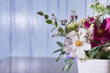 Mavi arka planda bir buket yabani çiçek.                                 