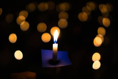 Mum alevi go ışık ile karanlık arka plan üzerinde bokeh ile mübarek gece kutsallık ve mucizeler ışıktır.