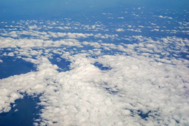 Gökyüzü ve bulutlar ve uçağın penceresinde beliren görünümü
