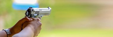 Sancak boyunda, atış poligonunda el ateş ediyor.