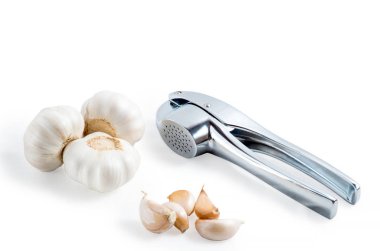 Metal sarımsak basın ve üzerinde beyaz izole sarımsak
