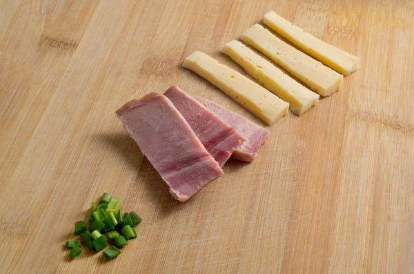 Cheese ham and green onion on wooden isolated