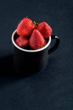 Siyah metal fincan taze olgun çilek