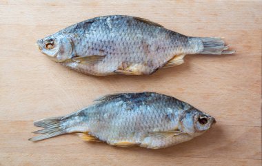 Masada kurutulmuş balık var. Ahşap bir arka plan üzerinde tuzlu kuru nehir balığı