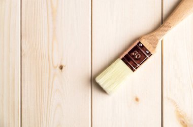 Ahşap yüzeyde yeni şeffaf boya fırçası