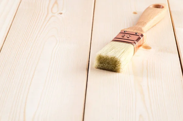 New clear paint brush on wooden surface