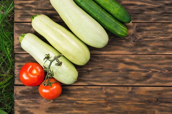 Tomatoes, cucumbers and squash on wooden boards — Stock Photo, Image