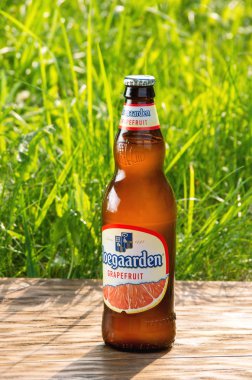 Saint-Petersburg, Rusya, 2 Haziran 2019 Taze yaz yeşil çim arka planda bira Hoegaarden Greyfurt şişe