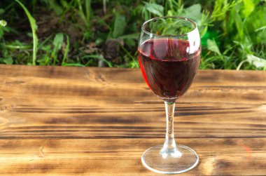 Paslı ahşap masada bir kadeh kırmızı şarap