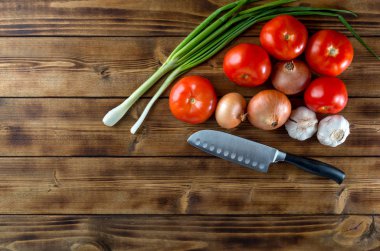 Koyu ahşap arka planda çiğ sebze ve bıçak