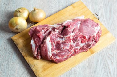 Ahşap tahtada çiğ et ve soğan