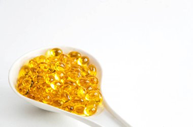 Beyaz backgound bir kaşık d vitamini kapsülleri