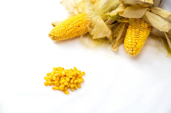 Nyers kukorica levelekkel és kukoricamagokkal fehér alapon — Stock Fotó