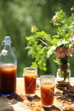 Ahşap bir masanın penceresinin yanında içinde kvass ve iki bardak olan bir şişe var.