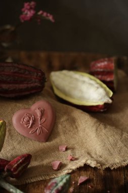 Tahta bir masada çikolata, kakao meyvesi.