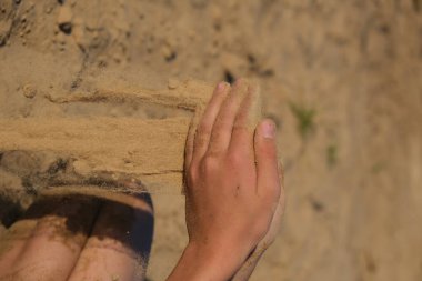 El çırpması altın kum parmaklarından dökülüyor, yazı için yer var.