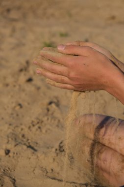 El çırpması altın kum parmaklarından dökülüyor, yazı için yer var.